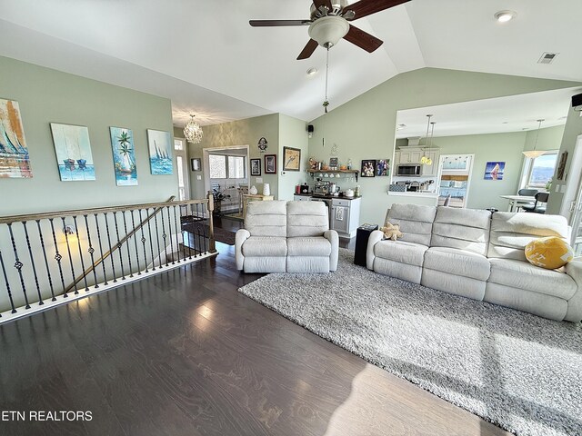 living area with plenty of natural light, visible vents, vaulted ceiling, and wood finished floors