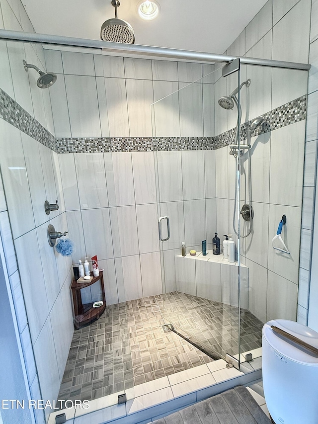 full bath featuring a stall shower and toilet