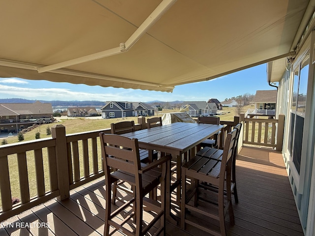 wooden terrace featuring a residential view, outdoor dining area, and a yard