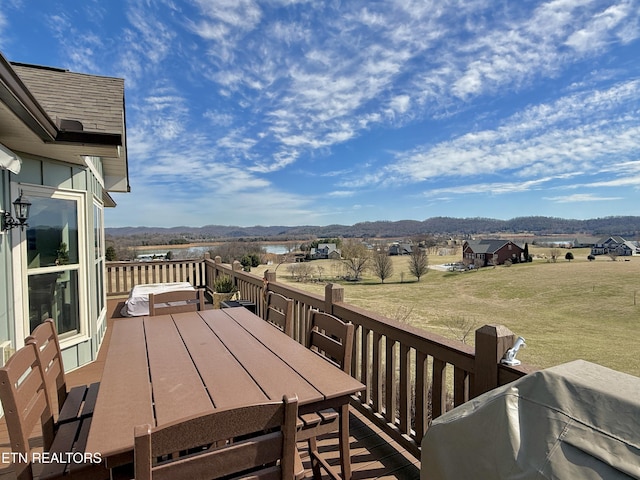 wooden deck with a mountain view and outdoor dining space