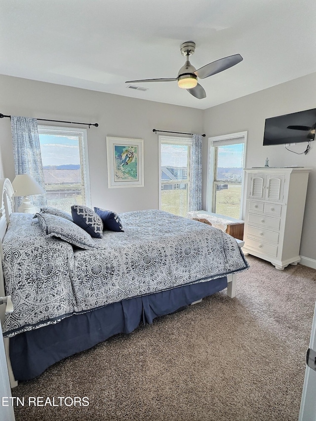 carpeted bedroom featuring visible vents, baseboards, and a ceiling fan