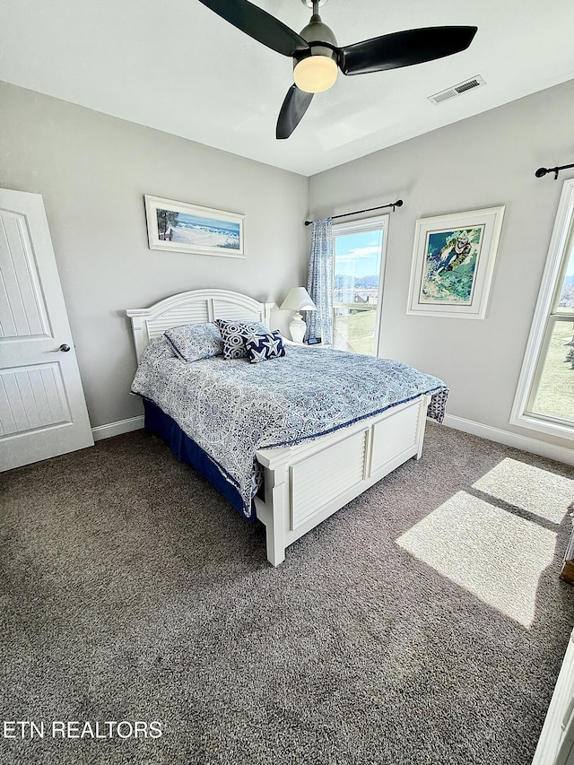 bedroom with visible vents, dark carpet, baseboards, and ceiling fan