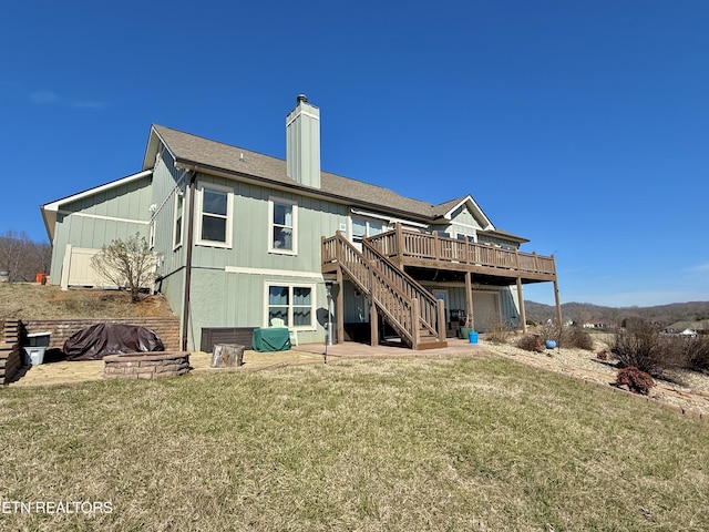 rear view of property featuring a chimney, a yard, stairs, a wooden deck, and a patio area