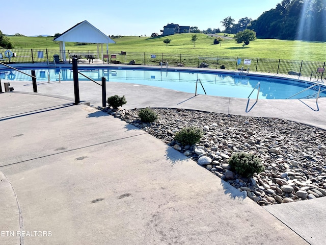 pool featuring a lawn and fence