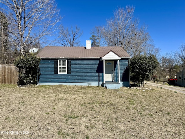 view of front of property featuring a chimney, metal roof, crawl space, fence, and a front yard