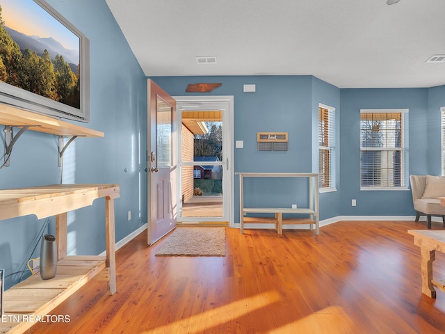 entrance foyer with wood finished floors, visible vents, and baseboards