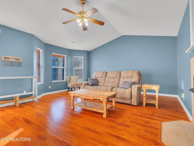 living room with baseboards, visible vents, a ceiling fan, lofted ceiling, and wood finished floors