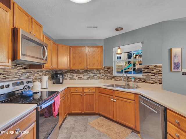 kitchen featuring light countertops, appliances with stainless steel finishes, a sink, and visible vents