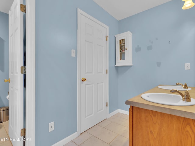 bathroom with tile patterned floors, a sink, and baseboards