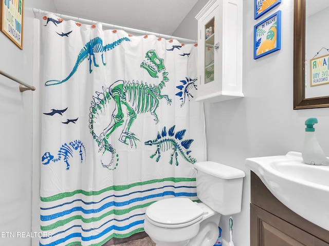 bathroom with curtained shower, vanity, and toilet