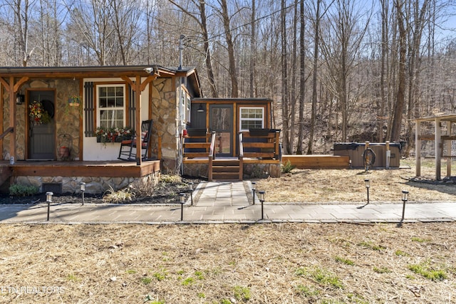 view of front of house with stone siding and covered porch