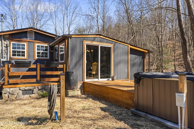 exterior space featuring a deck and a hot tub