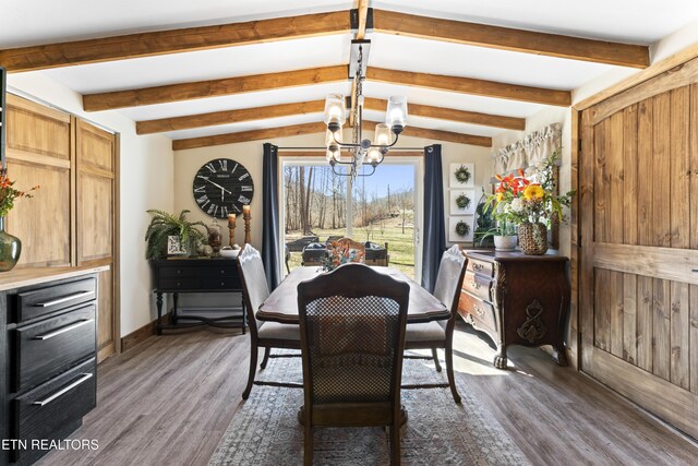 dining room featuring vaulted ceiling with beams, an inviting chandelier, baseboards, and wood finished floors