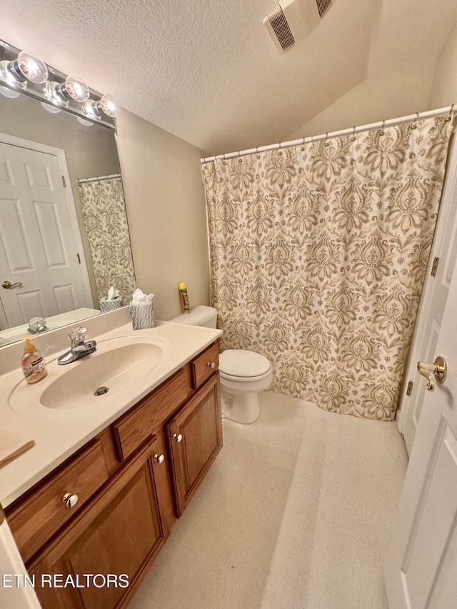 bathroom featuring a textured ceiling, toilet, and vanity