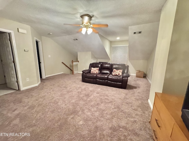 carpeted home theater room with visible vents, a ceiling fan, vaulted ceiling, a textured ceiling, and baseboards