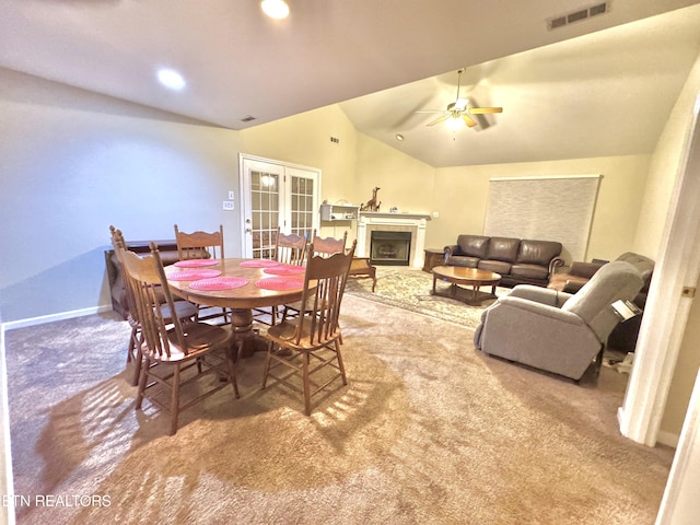 dining area featuring a fireplace, carpet flooring, visible vents, vaulted ceiling, and french doors