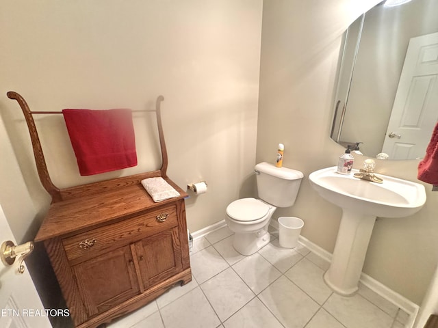 bathroom with toilet, tile patterned flooring, and baseboards