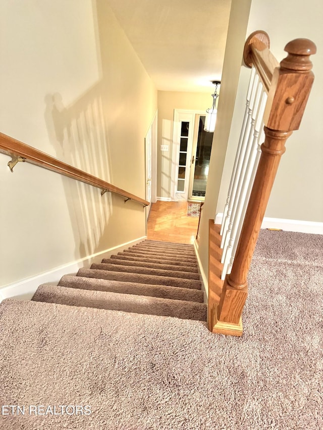 stairway with carpet flooring and baseboards