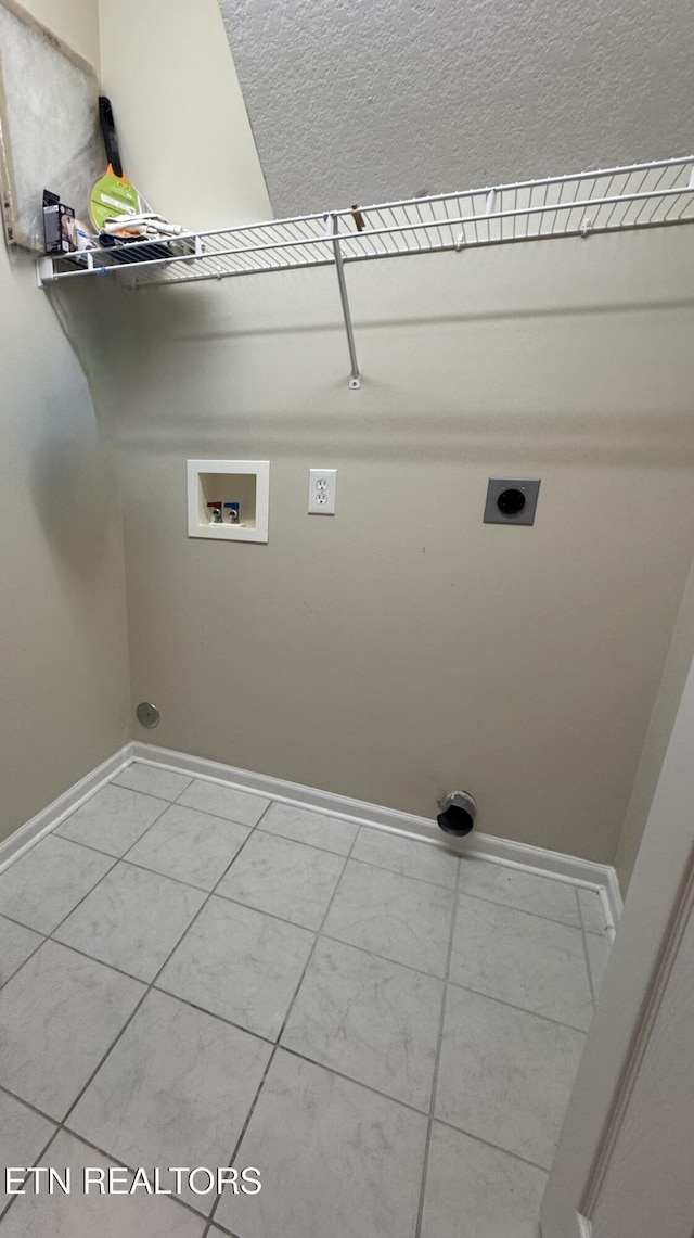 washroom with light tile patterned floors, hookup for a washing machine, electric dryer hookup, laundry area, and baseboards