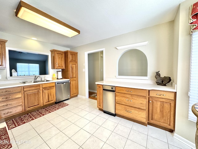 kitchen with light countertops, a sink, stainless steel dishwasher, and light tile patterned floors