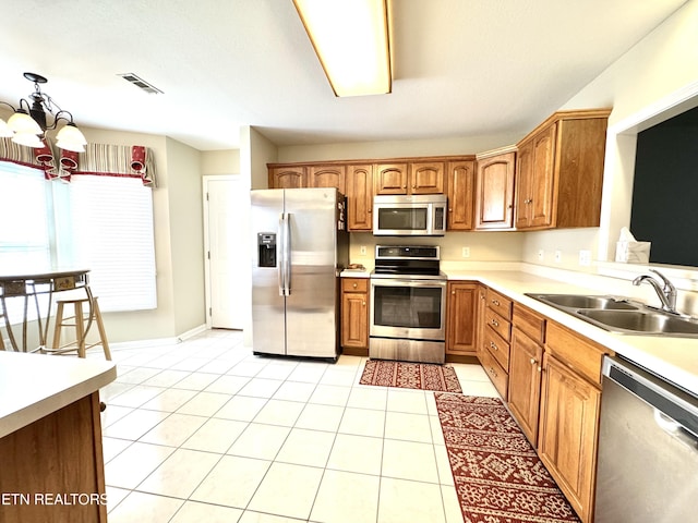 kitchen with light countertops, visible vents, appliances with stainless steel finishes, a sink, and a chandelier