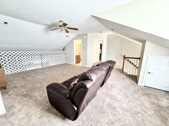 interior space with visible vents, baseboards, a ceiling fan, vaulted ceiling, and carpet floors