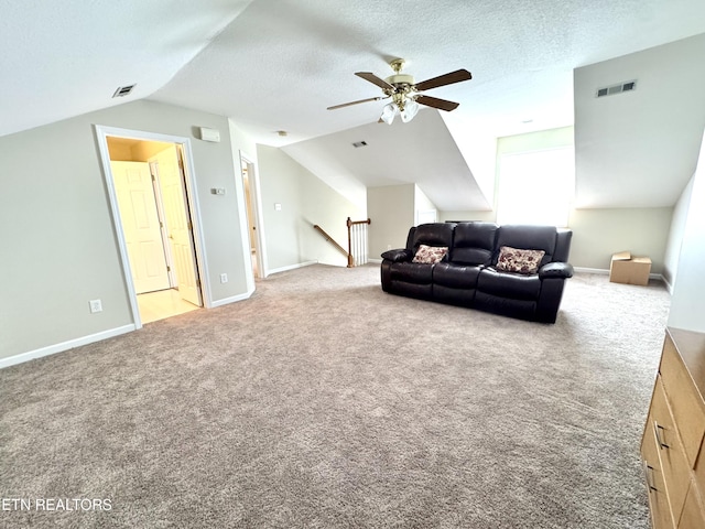 living room with a textured ceiling, carpet flooring, and visible vents