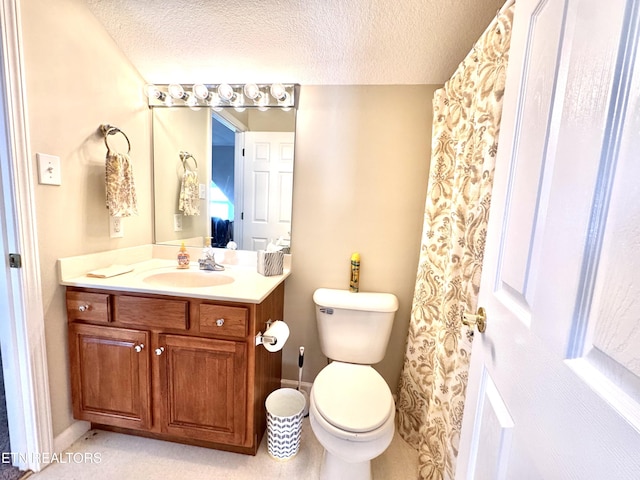 bathroom with a textured ceiling, toilet, and vanity