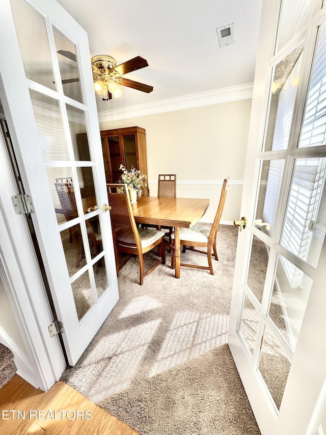 dining area with french doors, visible vents, crown molding, and wood finished floors