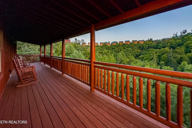 wooden terrace featuring a forest view