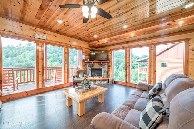 living area featuring wooden ceiling, wood finished floors, a healthy amount of sunlight, wood walls, and a fireplace