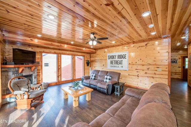 living room with wooden ceiling, wood walls, a stone fireplace, and wood finished floors