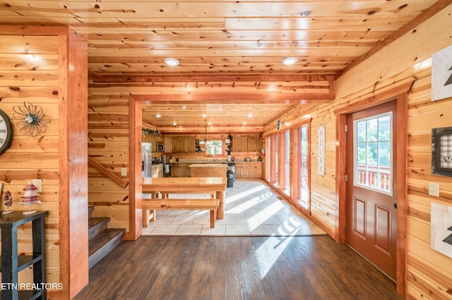 dining area featuring wood ceiling, stairs, wooden walls, and dark wood finished floors