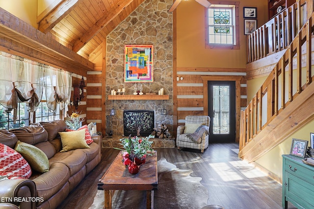 living room with beam ceiling, a fireplace, stairway, wood ceiling, and wood finished floors