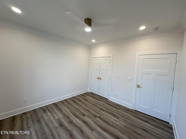 unfurnished bedroom with baseboards, dark wood-style floors, ornamental molding, a closet, and recessed lighting