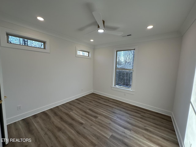 spare room featuring baseboards, visible vents, dark wood finished floors, ornamental molding, and recessed lighting