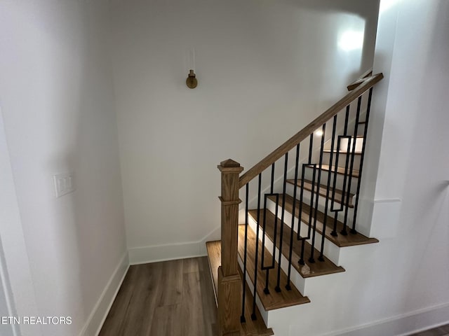 stairs featuring wood finished floors and baseboards