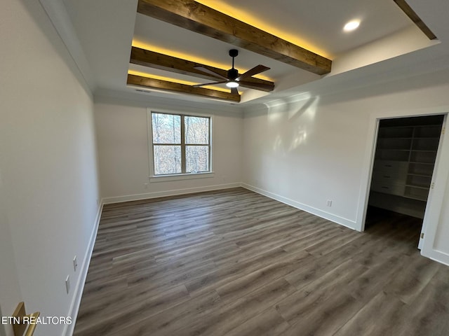 unfurnished bedroom with dark wood-style floors, a tray ceiling, beamed ceiling, and baseboards