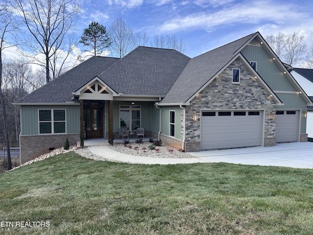 craftsman house with a front lawn, concrete driveway, a garage, and a shingled roof