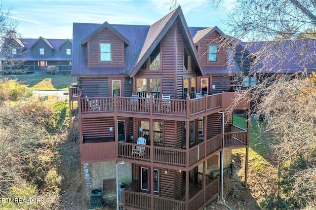 back of house featuring central AC unit, metal roof, and a wooden deck