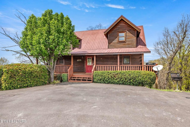 log cabin featuring a porch and metal roof