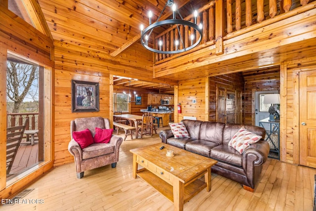 living area featuring high vaulted ceiling, hardwood / wood-style flooring, and wooden walls