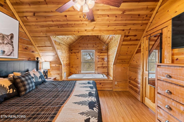 bedroom with lofted ceiling, wooden ceiling, wood finished floors, and wooden walls