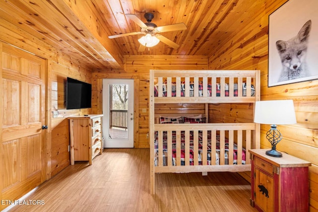 bedroom featuring wood walls, wood finished floors, and wood ceiling