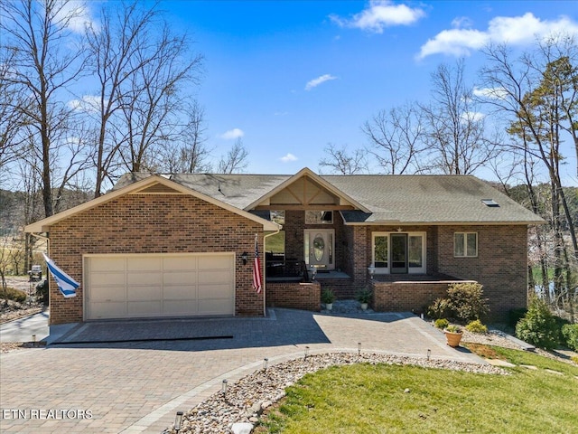 ranch-style house with roof with shingles, brick siding, decorative driveway, and an attached garage