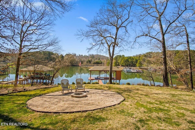 exterior space featuring a boat dock, a water view, boat lift, and a fire pit