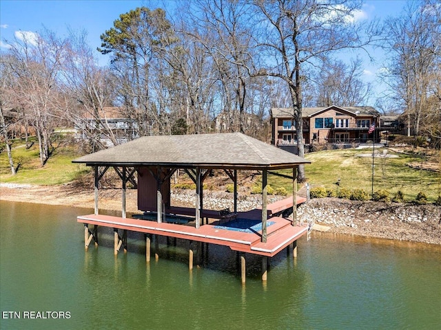 dock area featuring a water view, a yard, and boat lift