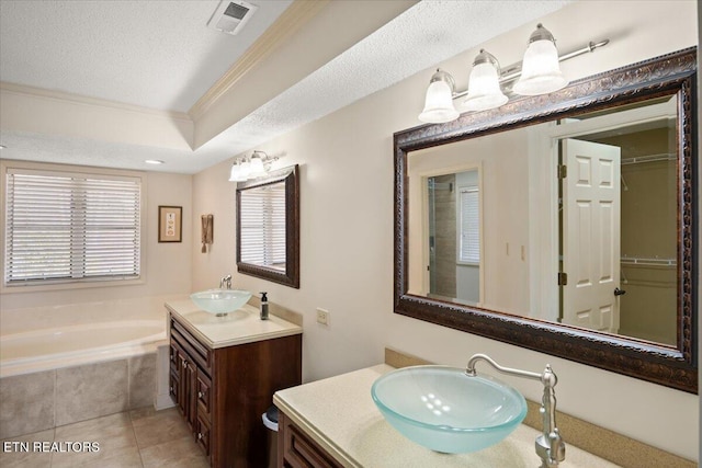 full bathroom featuring a textured ceiling, tile patterned flooring, a sink, visible vents, and ornamental molding