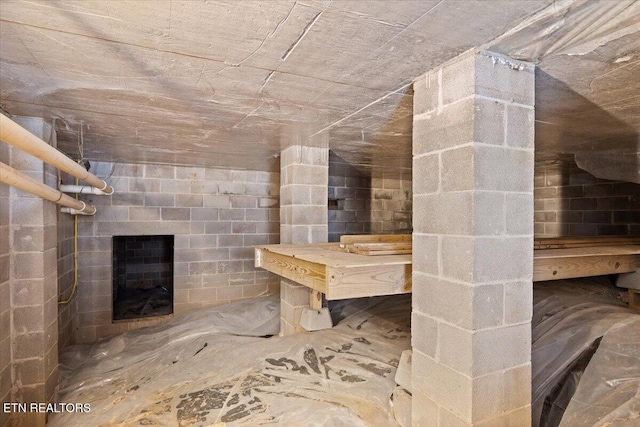 bathroom with concrete block wall and a fireplace