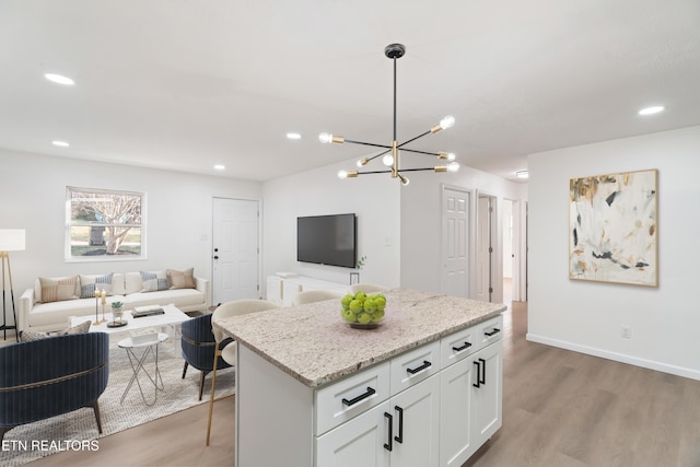 2247 W Gilbert Ln, Knoxville, TN 37920 - kitchen with open floor plan, light wood-style flooring, a chandelier, white cabinets, and recessed lighting